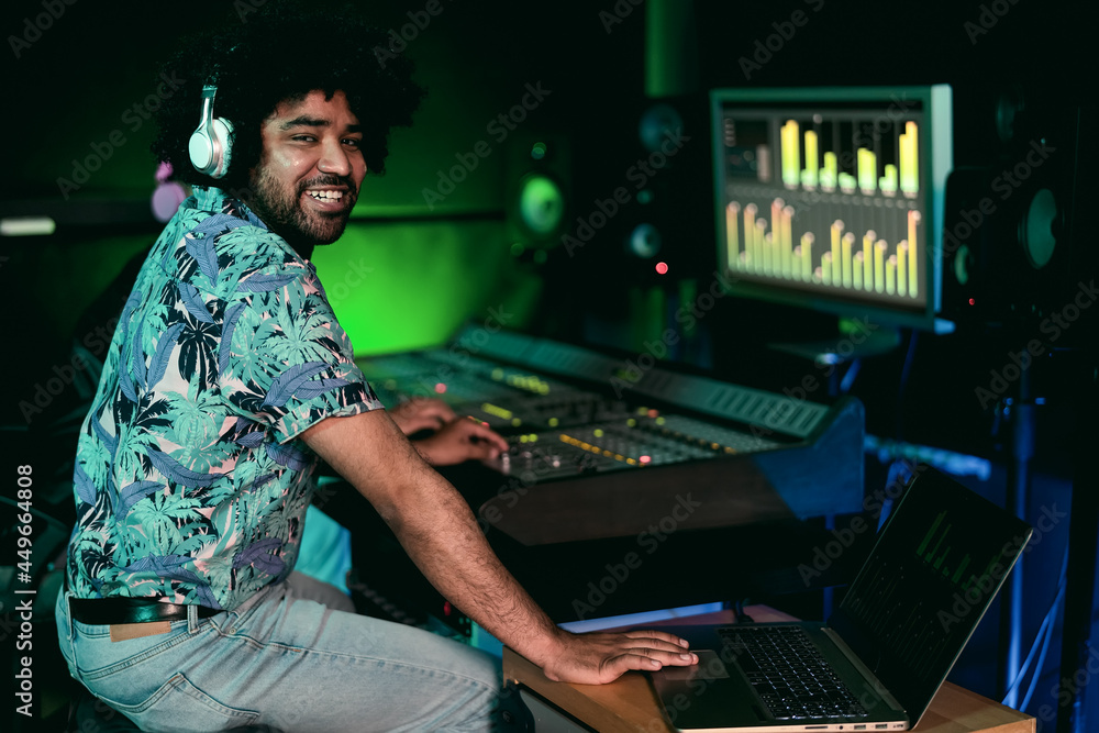 Young Afro man working in music recording studio - Male audio engineer mixing a sound in production house Young Afro man working in music recording studio - Male audio engineer mixing a sound in production house