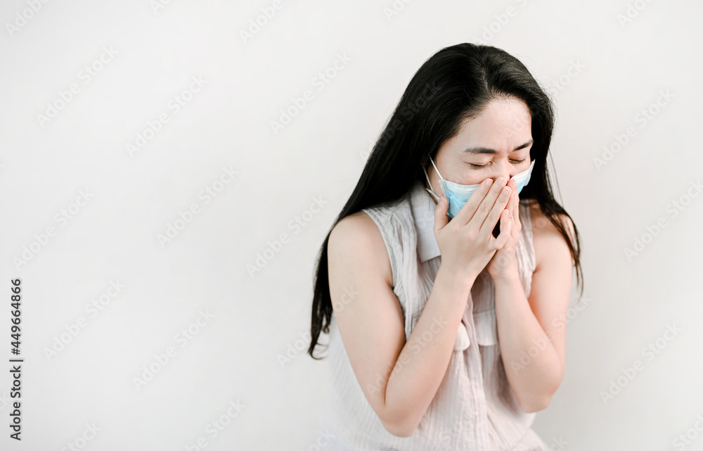 unhealthy woman wear face mask is sneezing and look illness. unhealthy woman wear face mask is sneezing and look illness.