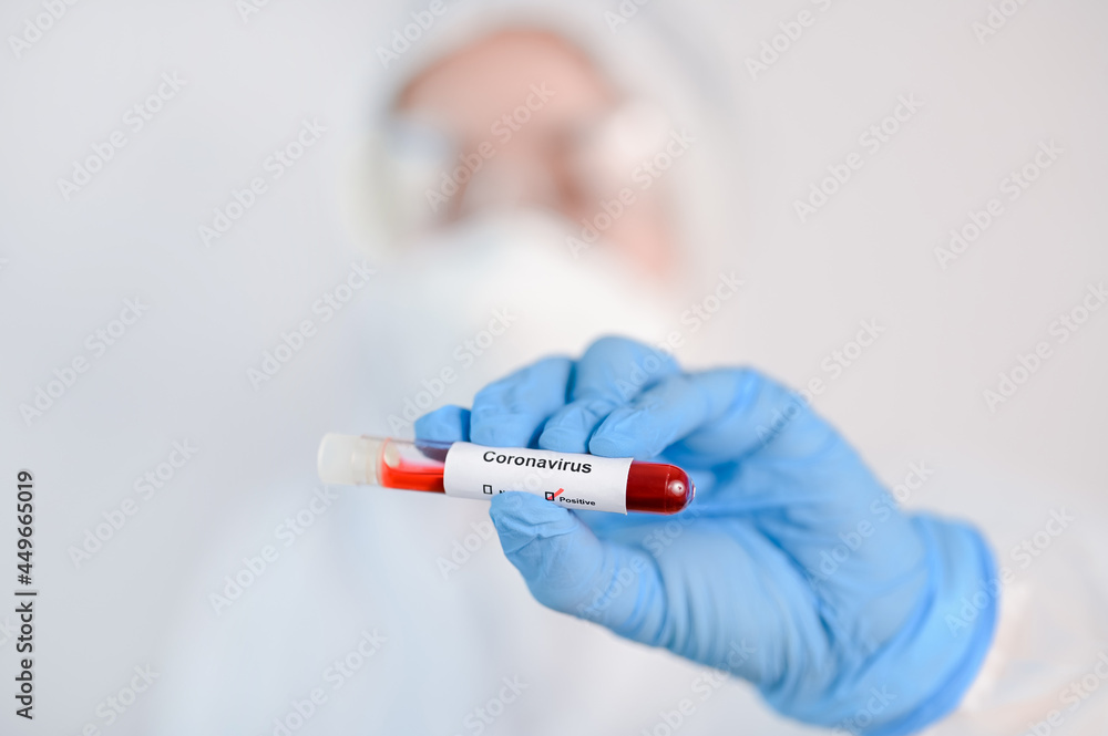 Selective focus of Corona virus blood sample in doctor hand in PPE suit. Selective focus of Corona virus blood sample in doctor hand in PPE suit.