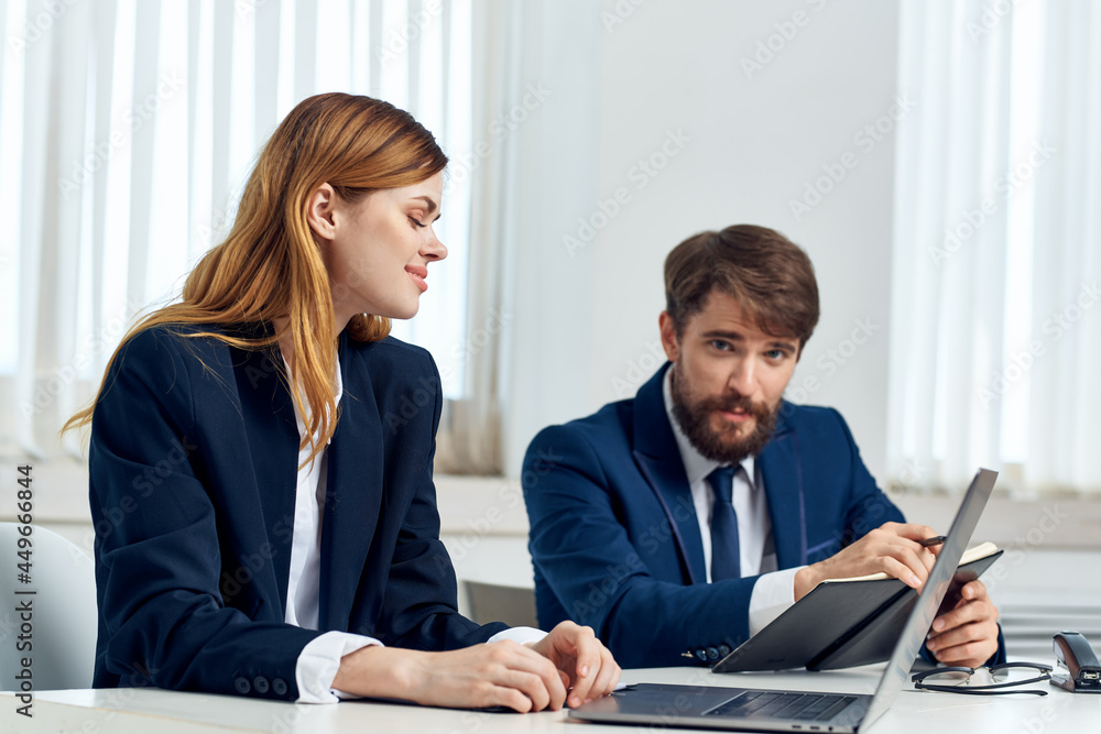 man and woman managers talking at the table in front of laptop office technology man and woman managers talking at the table in front of laptop office technology