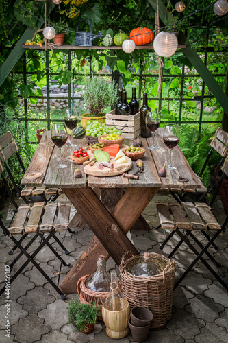 Garden table with wine and appetizers Garden summer evening.