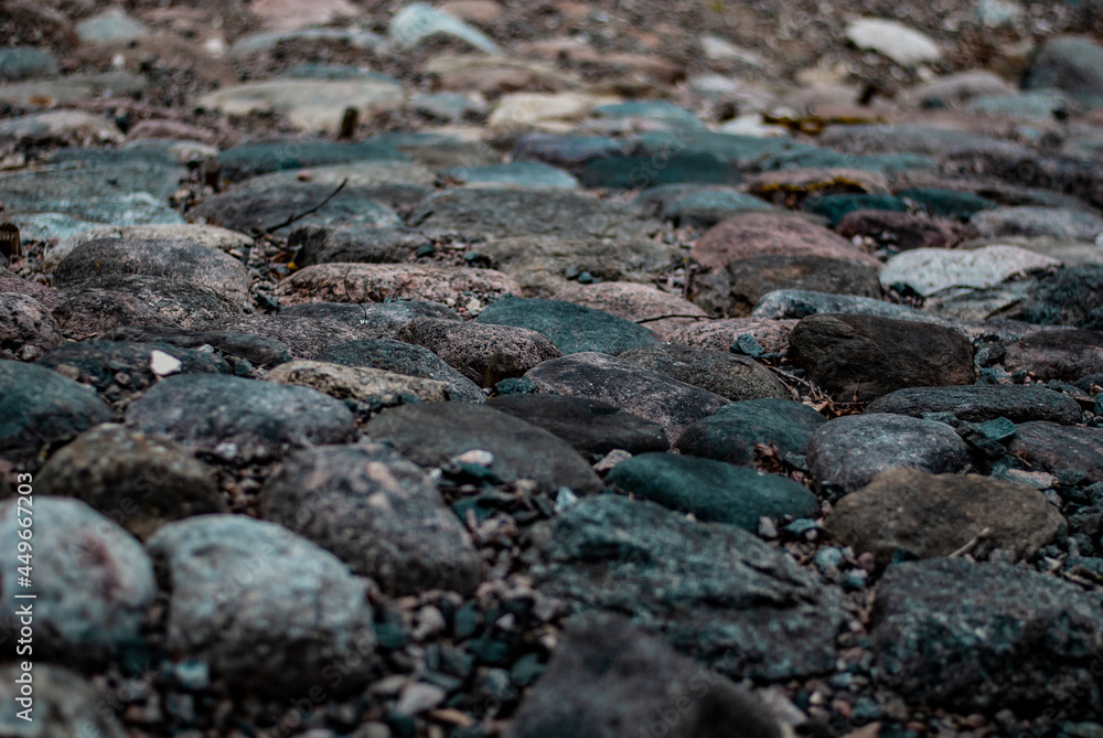 Obraz premium Large rounded stones on the road look like a pavement with small stones between the stones