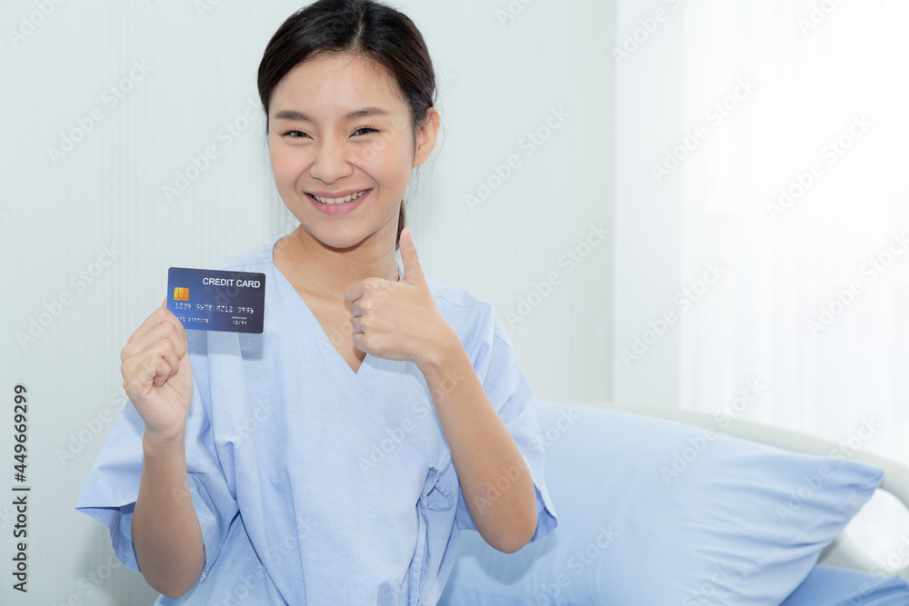 Portrait young Asian female patients show a demo credit card in hand. Show health insurance card for medical expense. Accident, insurance business concept. Portrait young Asian female patients show a demo credit card in hand. Show health insurance card for medical expense. Accident, insurance business concept.