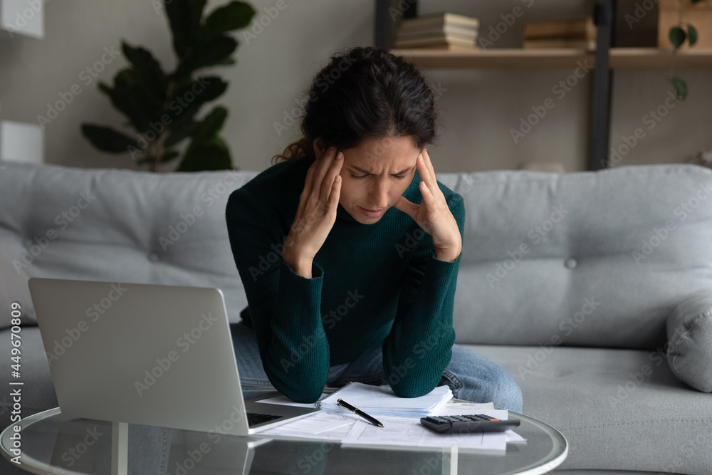 Close up stressed woman calculating bills, having problem with money, depressed young female touching temples, businesswoman or tenant feeling anxiety and nervous about debt or bankruptcy Close up stressed woman calculating bills, having problem with money, depressed young female touching temples, businesswoman or tenant feeling anxiety and nervous about debt or bankruptcy