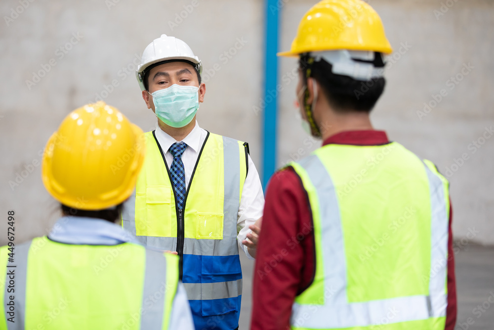 factory worker wearing medical face mask and talking about work with colleague factory worker wearing medical face mask and talking about work with colleague