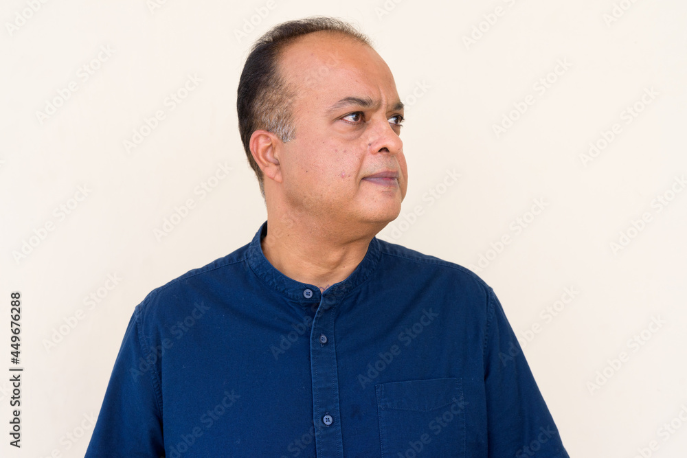 Portrait of Indian man thinking against plain wall outdoors Portrait of Indian man thinking against plain wall outdoors