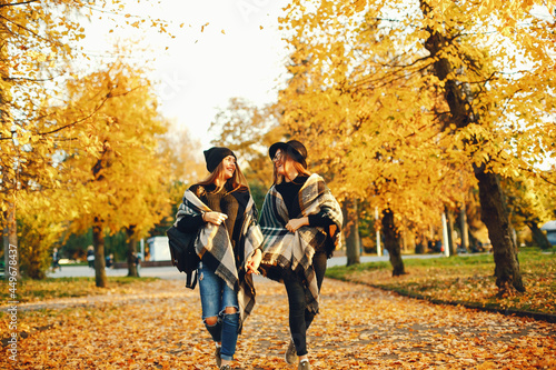 two young girls walk around the city in the autumn city and park © prostooleh