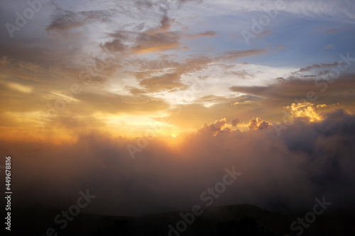 Destination and paradise of golden sunrise and sunset shining to the mist and fog in the jungle on the valley mountain. Aerial view of Rainy season in the tropical rainforest in Thailand.