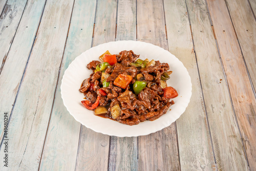 Dish of minced and sautéed beef with peppers, onions and bamboo wok with oyster sauce cooked with the recipe of a Chinese chef