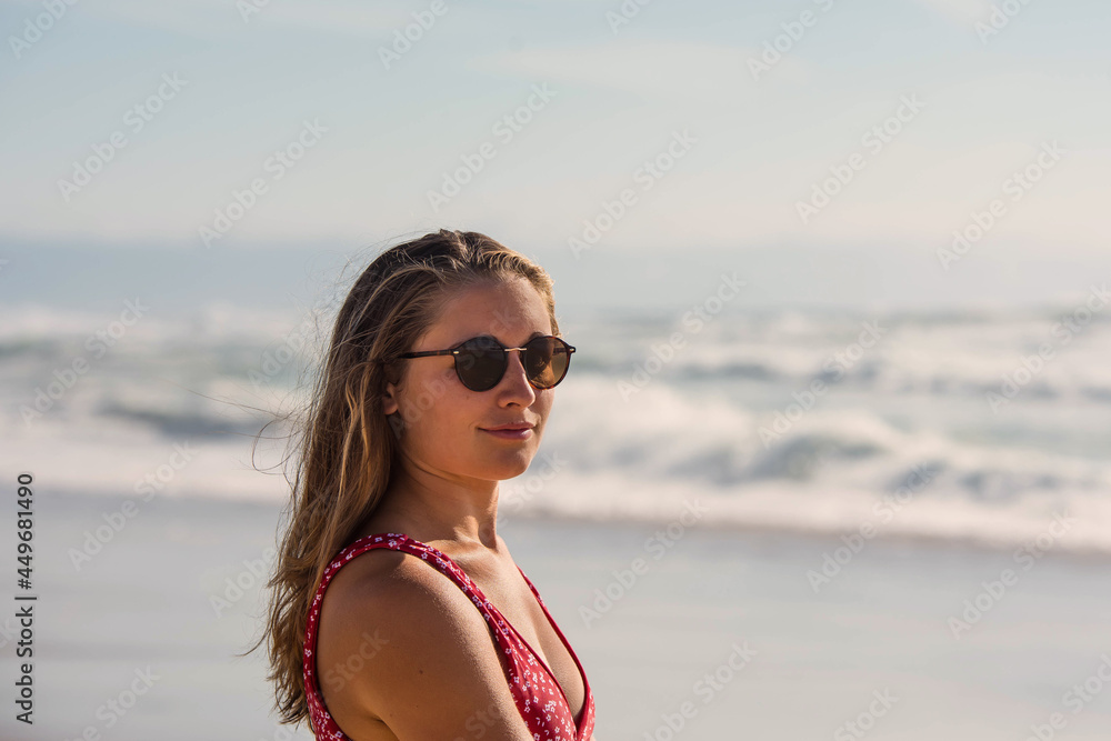 portrait of a pretty young woman walking barefoot on the beach