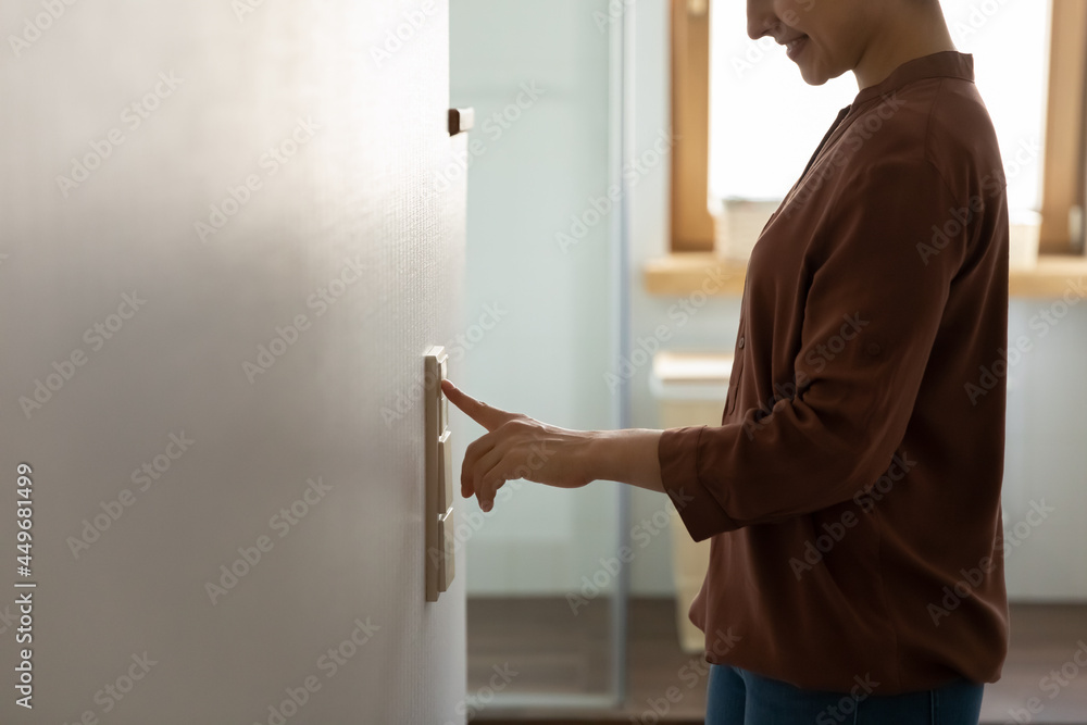 © fizkes - Crop close up of smiling young Indian woman turn on off lights in cozy home living room. Happy ethnic female renter or tenant switch modern smart home electronic gadget. Energy saving concept. © fizkes - Crop close up of smiling young Indian woman turn on off lights in cozy home living room. Happy ethnic female renter or tenant switch modern smart home electronic gadget. Energy saving concept.