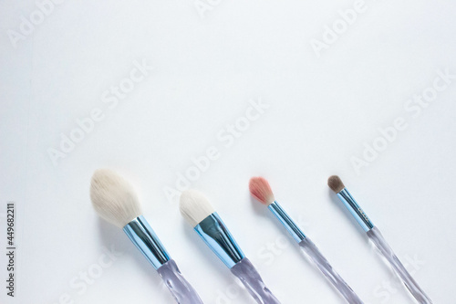 Brushes a flat lay with copy space. Beauty cosmetic makeup product layout. Stylish design. Creative fashionable concept. Cosmetics make-up brushes collection on a white background, top view. 