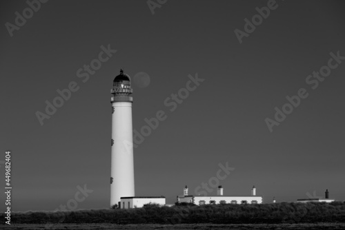 the full moon lines up with the lantern of the lighthouse in mono