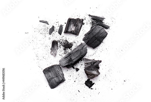 Fotografija Close-up of pieces broken wooden coal, ash, black powder isolated on white