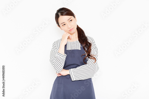 困っているエプロン姿の女性