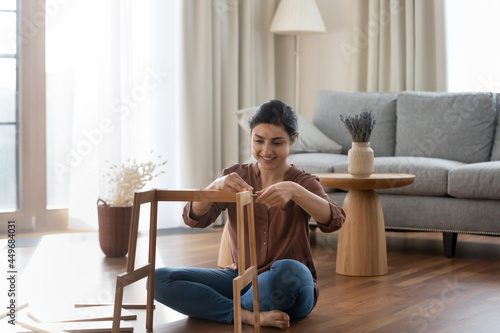 Cuadro en lienzo Happy millennial Indian female renter or tenant sit on floor in new house gather shelf