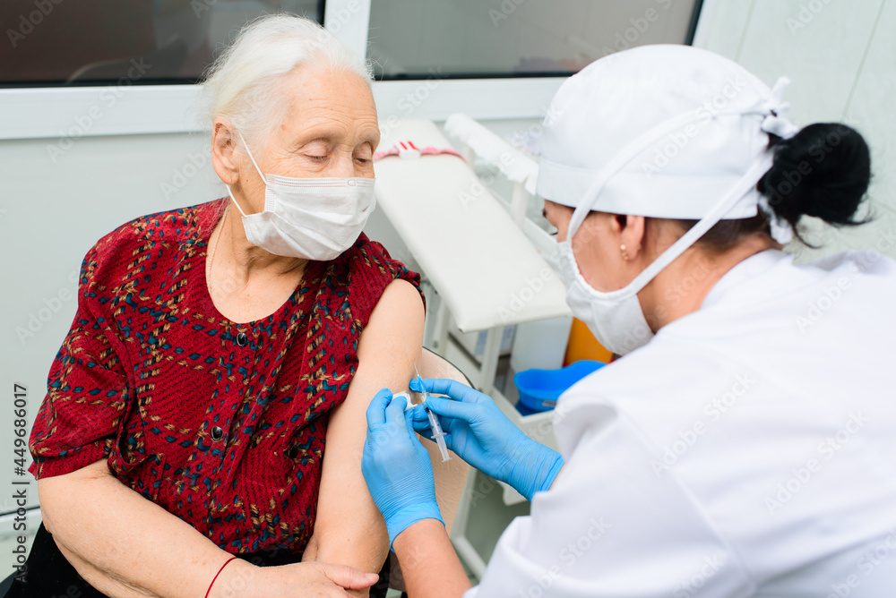 a doctor or nurse injects a drug or vaccine into an elderly woman's shoulder. Vaccination against covid-19, diabetes, insulin. a doctor or nurse injects a drug or vaccine into an elderly woman's shoulder. Vaccination against covid-19, diabetes, insulin.