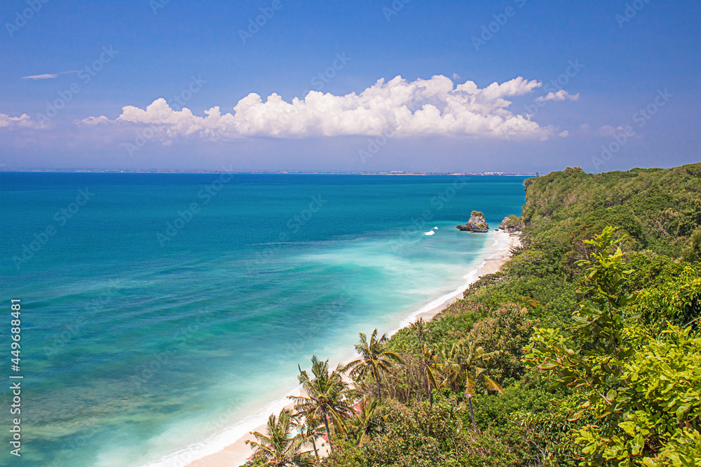 Beautiful tropical beach Bali, Indonesia. Seascape with a small island in the background.