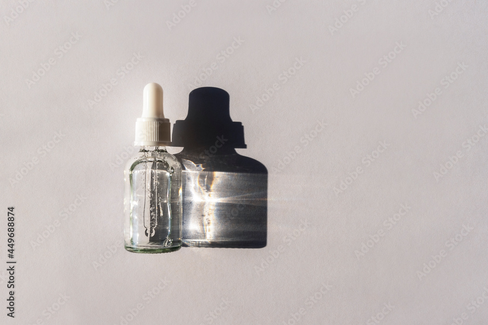 Bottle of natural skincare lotion on light grey background with harsh shadow. Trendy selfcare products. Top view, flat lay Bottle of natural skincare lotion on light grey background with harsh shadow. Trendy selfcare products. Top view, flat lay