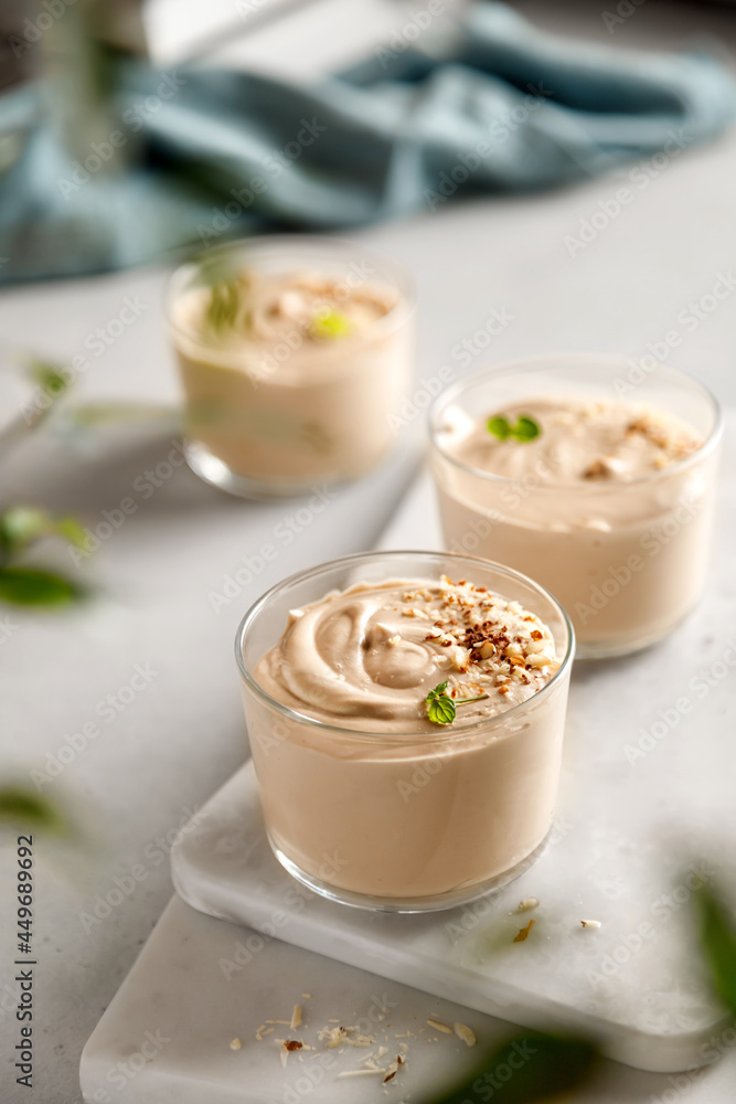 mousse dessert with nutella, chocolate paste, cheese and cream with nuts on the table and on the board mousse dessert with nutella, chocolate paste, cheese and cream with nuts on the table and on the board