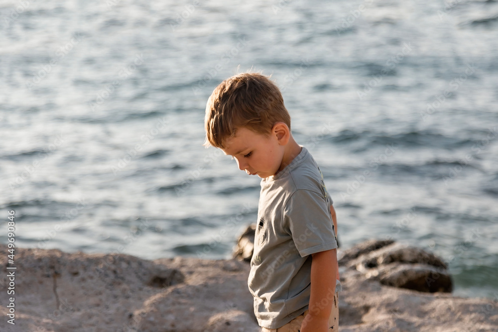 A child is playing on the beach. Rocky shore. Summer evening. A child is playing on the beach. Rocky shore. Summer evening.