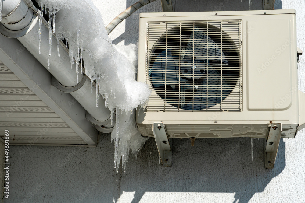 An outdoor air conditioner unit installed on the outer wall of a