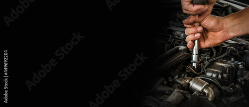 Фотография Auto mechanic working on car engine in mechanics garage