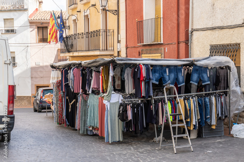 Clothing market store set up in the square of a small town. © MiguelAngel