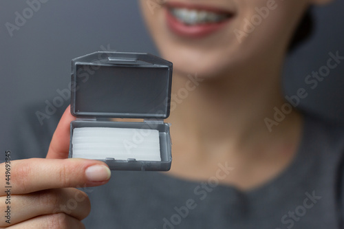 Obraz na płótnie Woman with braces is holding orthodontic wax. w salonie