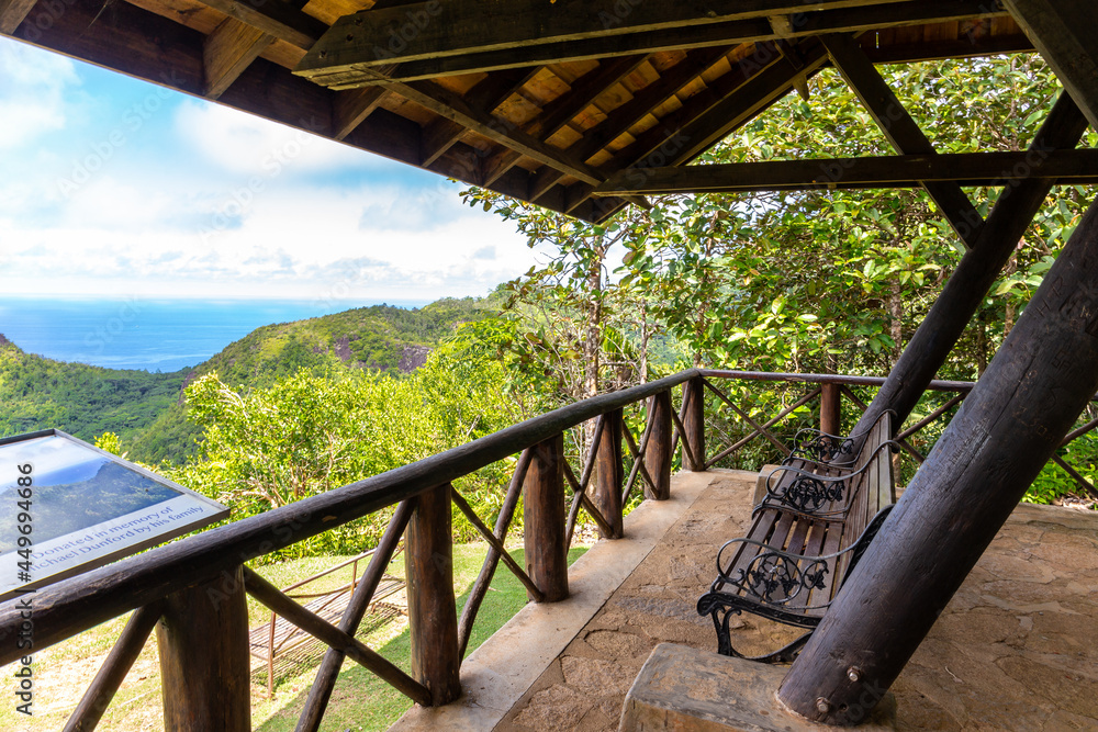 Venn's Town - Mission Lodge wooden viewing platform with benches and panoramic map overlooking lush tropical forest and island coast.