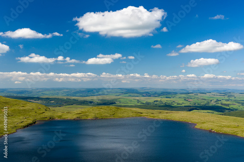 Aerial view of a lake formed at the base of green mountains  Llyn y Fan Fach  Brecon Beacons  Wales 