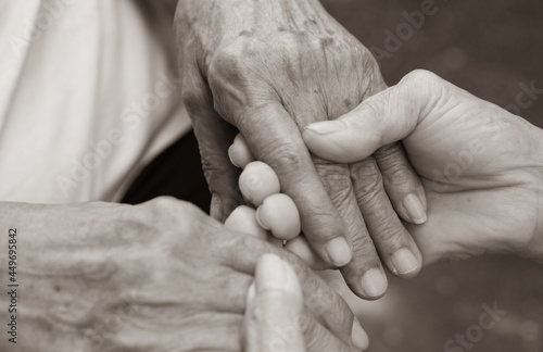Caregiver, carer hand holding elder hand in hospice care. Philanthropy kindness to disabled concept. photo