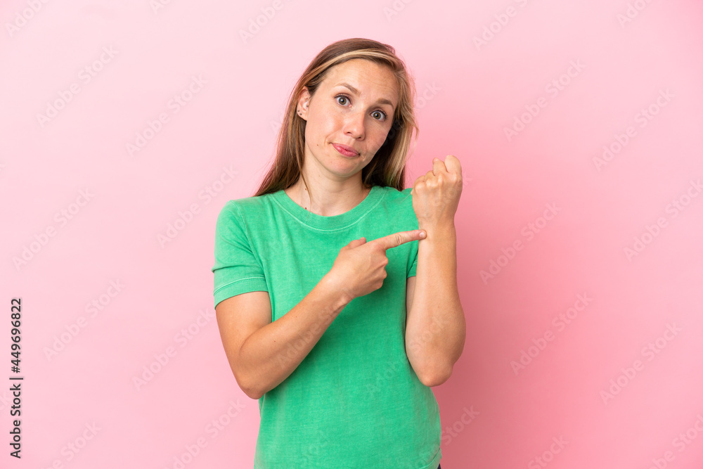 Young English woman isolated on pink background making the gesture of being late Young English woman isolated on pink background making the gesture of being late