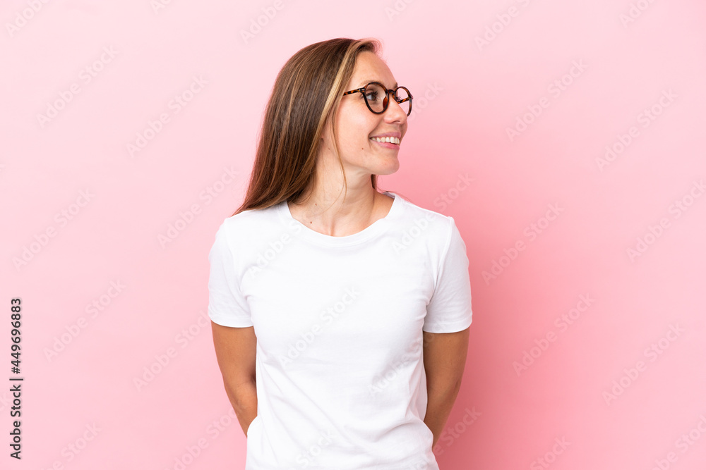 Young English woman isolated on pink background looking to the side and smiling Young English woman isolated on pink background looking to the side and smiling