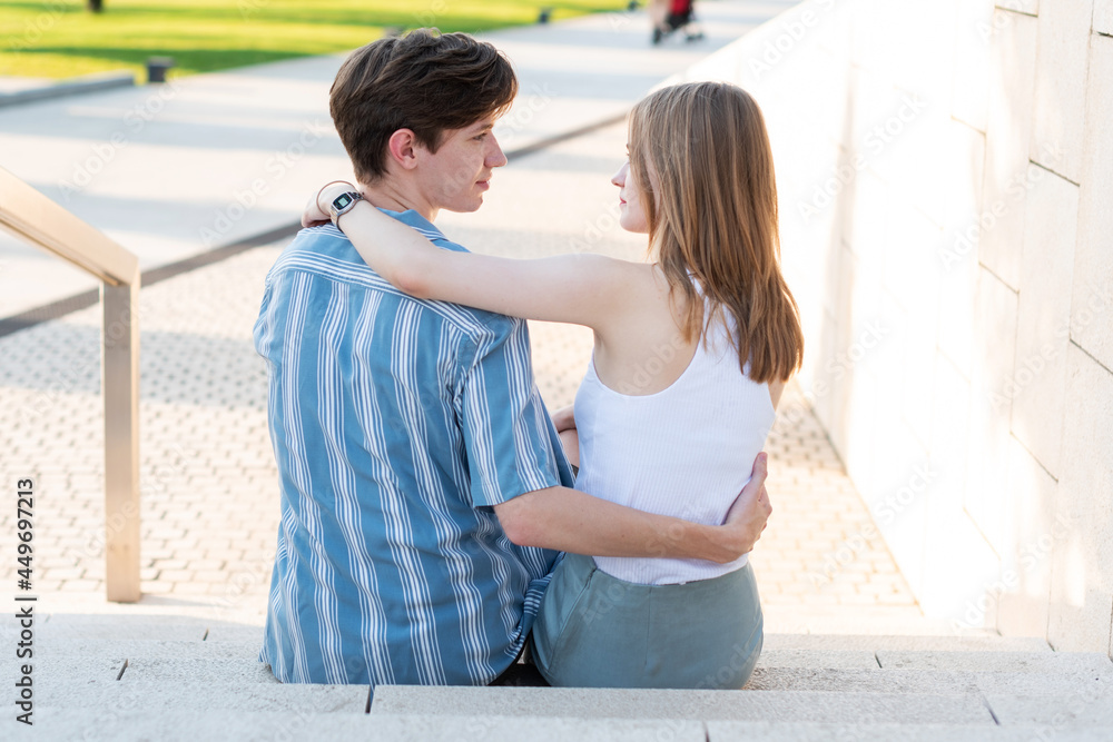 Couple of teenagers holding hands and hugging in the park. The first love Couple of teenagers holding hands and hugging in the park. The first love