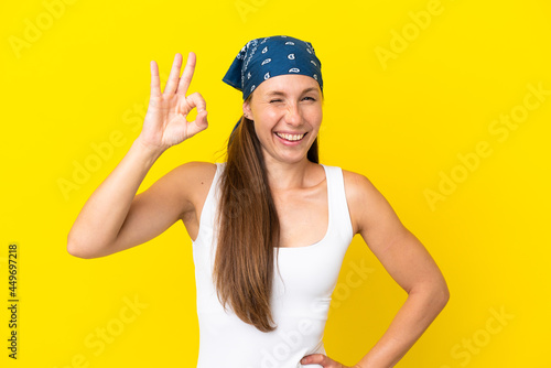 Young English woman isolated on yellow background showing ok sign with fingers