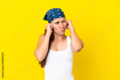 Young English woman isolated on yellow background frustrated and covering ears