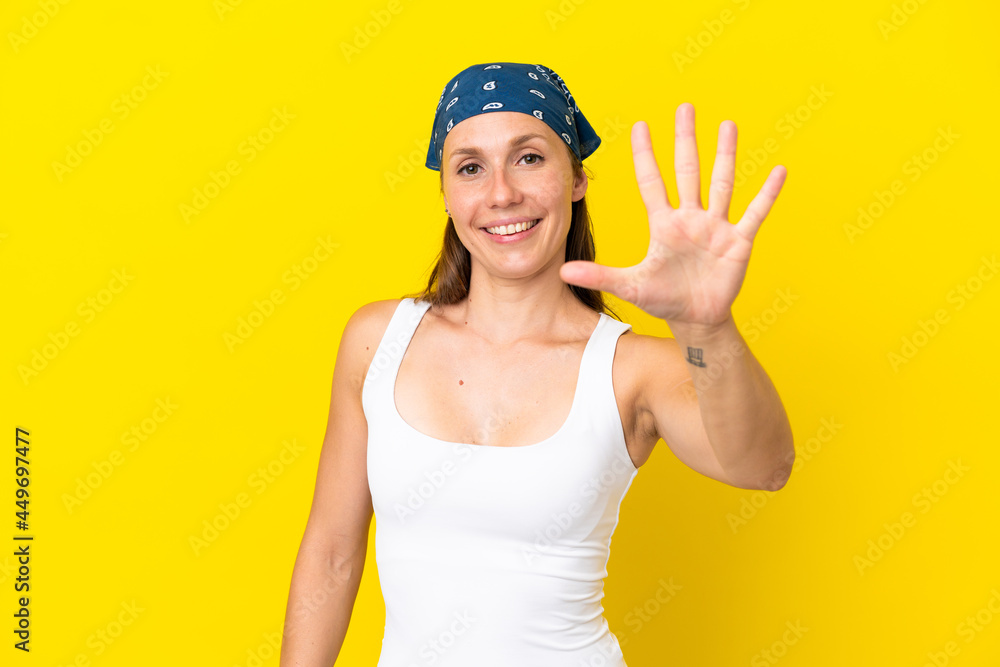 Young English woman isolated on yellow background counting five with fingers Young English woman isolated on yellow background counting five with fingers