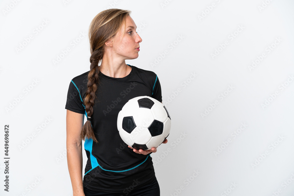 Young football player woman isolated on white background looking to the side
