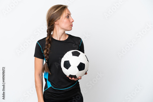 Young football player woman isolated on white background looking to the side © luismolinero