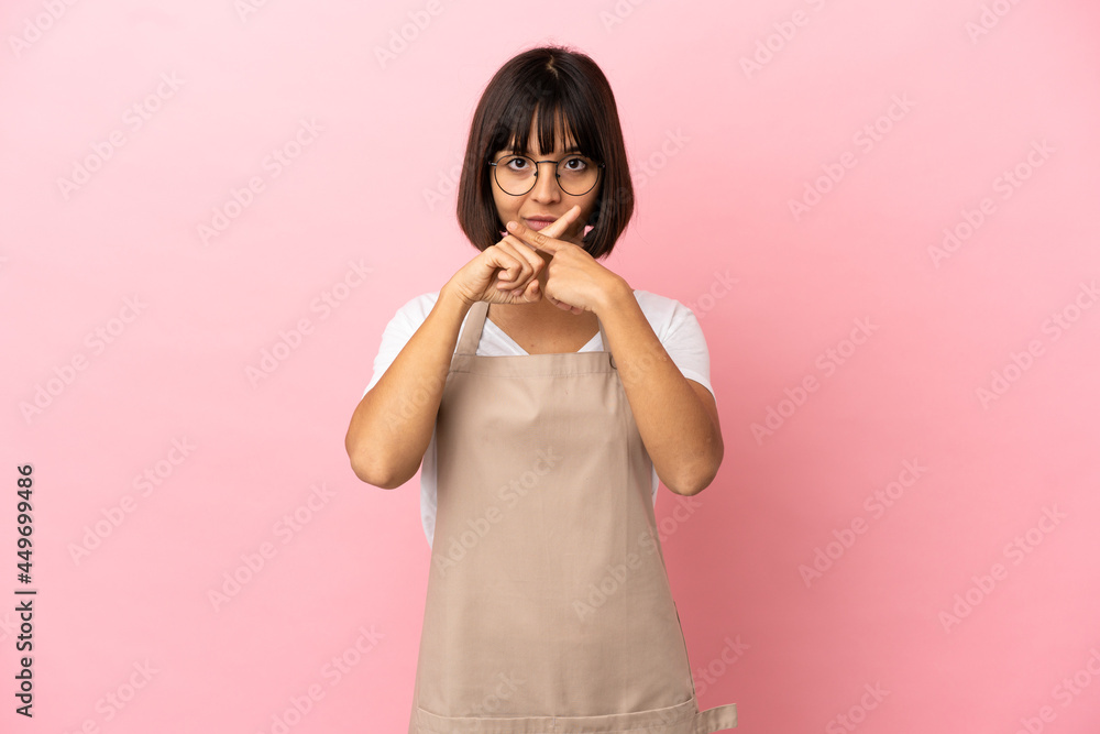 Restaurant waiter over isolated pink background showing a sign of silence gesture Restaurant waiter over isolated pink background showing a sign of silence gesture