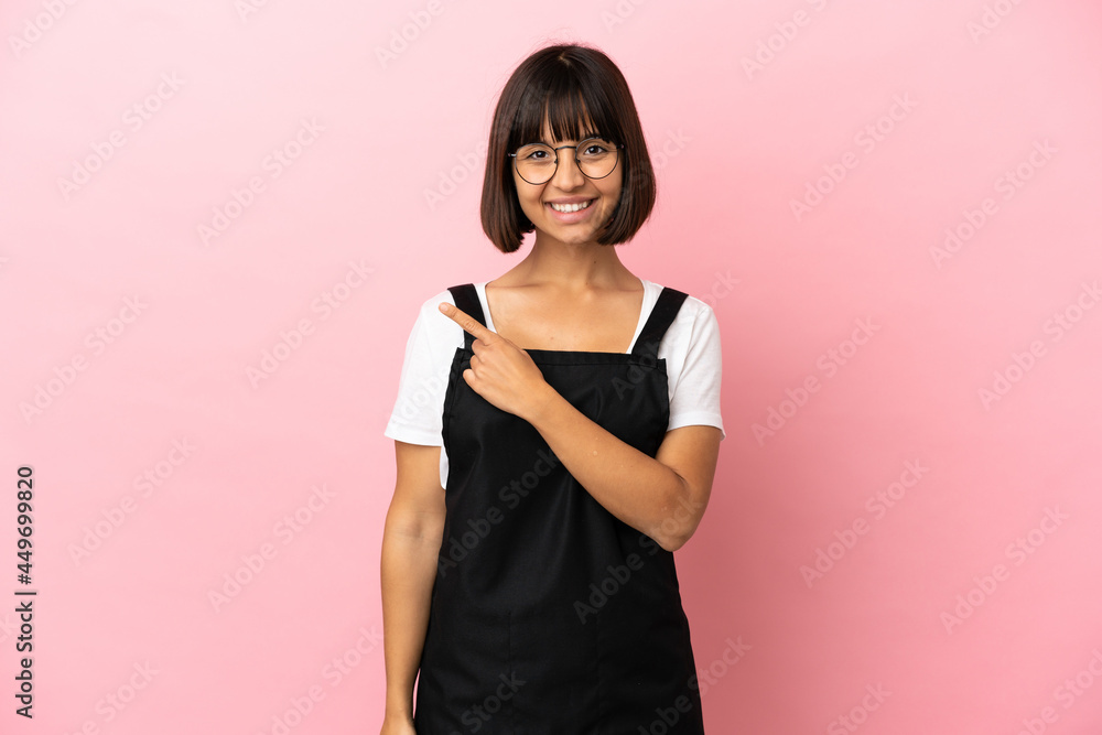 Restaurant waiter over isolated pink background pointing to the side to present a product Restaurant waiter over isolated pink background pointing to the side to present a product