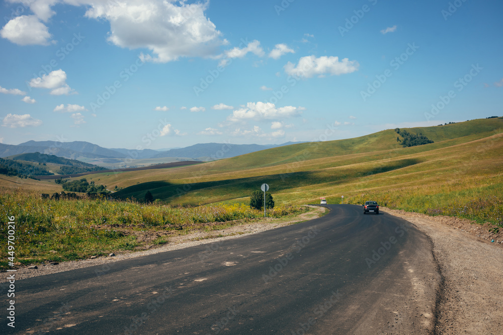 A highway among green hills. Summer. Blue sky and green grass. A highway among green hills. Summer. Blue sky and green grass.