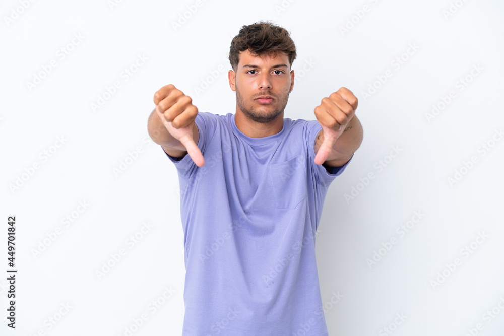 Young caucasian handsome man isolated on white background showing thumb down with two hands Young caucasian handsome man isolated on white background showing thumb down with two hands