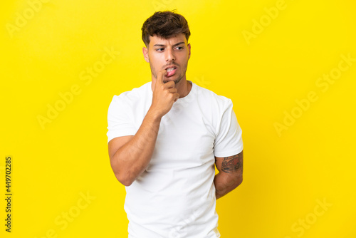 Young caucasian handsome man isolated on yellow background nervous and scared