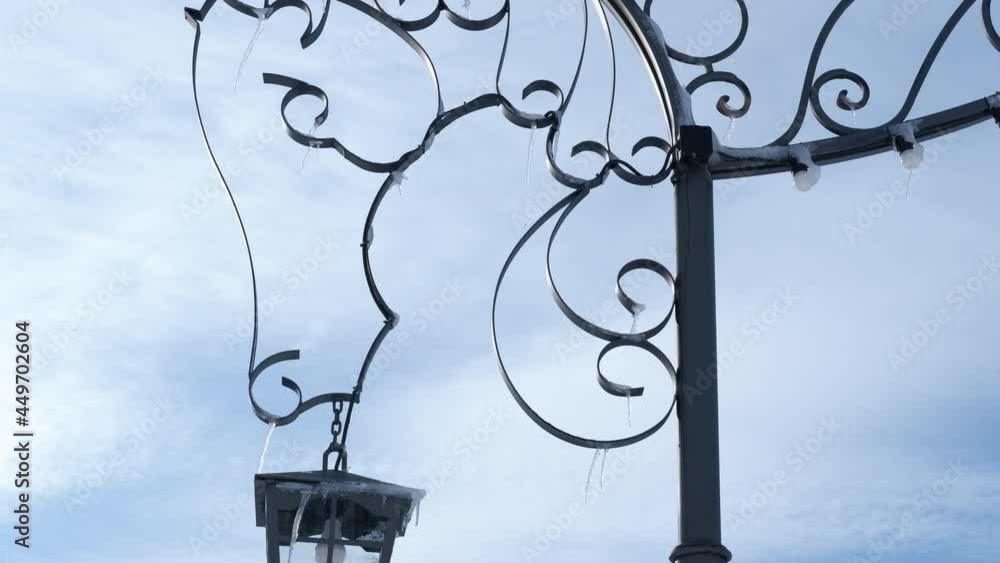 Iced street lamp. A view of a frozen street lamp on the background of winter sky. Iced street lamp. A view of a frozen street lamp on the background of winter sky.