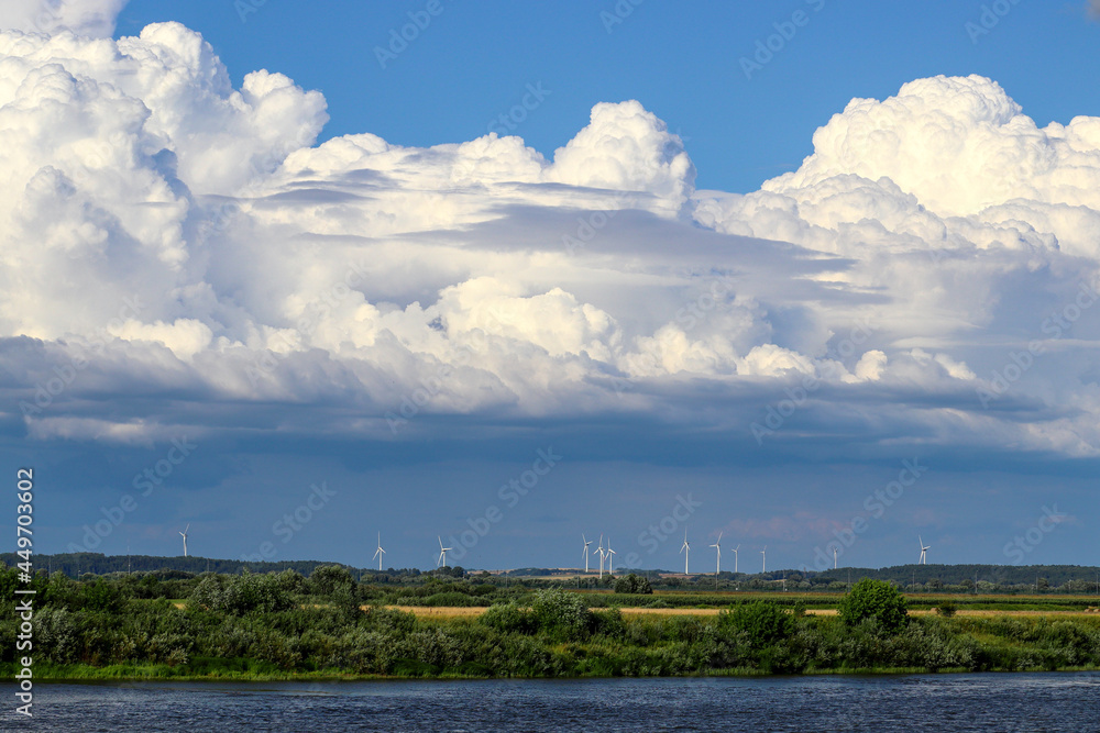 White cumulonimbus clouds of a cold atmospheric front over a field in summer, Lithuania
