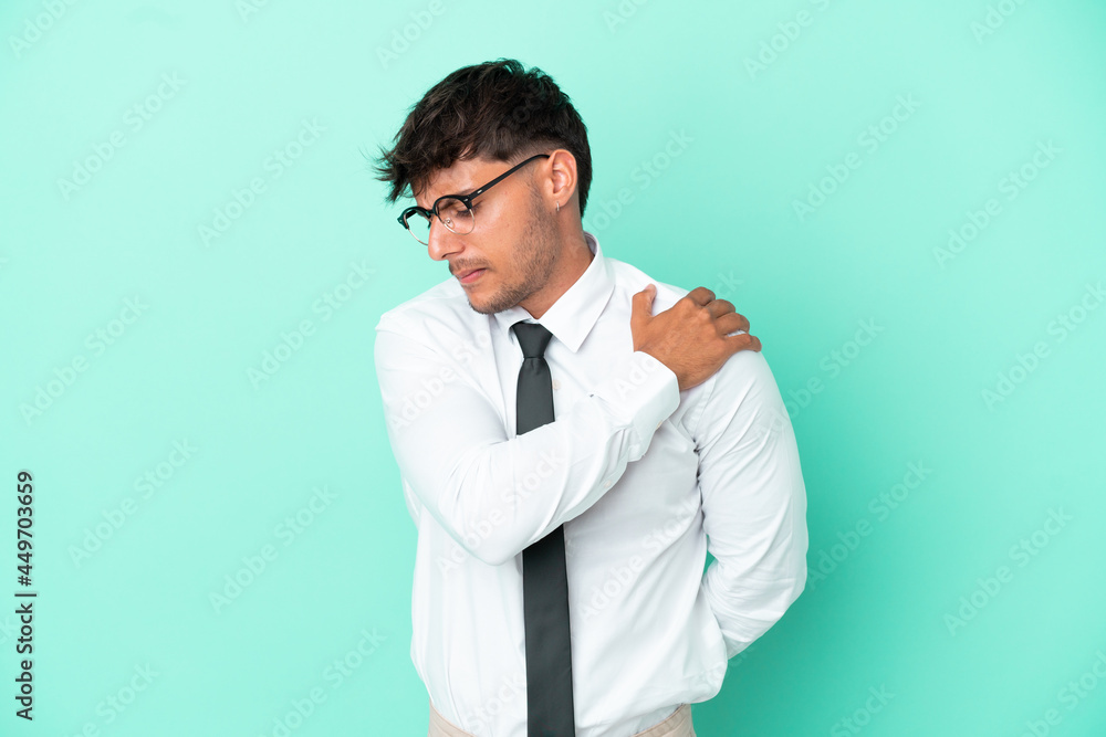 Business caucasian man isolated on blue background suffering from pain in shoulder for having made an effort Business caucasian man isolated on blue background suffering from pain in shoulder for having made an effort