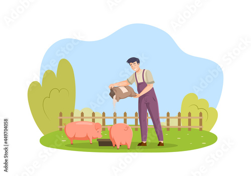Happy male farmer in overalls feeding pig man agricultural worker giving food to farm animals