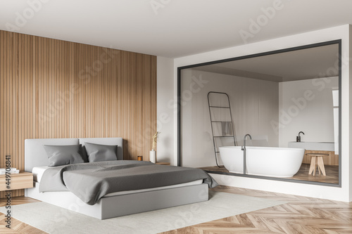Modern bedroom with glass wall of bathroom and parquet floor. Corner view